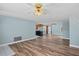 Open-concept living area with wood-look floors and easy access to kitchen and hallway at 8317 Needles Dr, Hudson, FL 34667