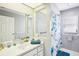 Bright bathroom features a large mirror over the vanity, blue accents, and a shower-tub combination at 8804 Poe Dr, Hudson, FL 34667