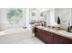 Luxurious bathroom with a soaking tub, double vanity, and a separate glass-enclosed shower, offering spa-like comfort at 8804 Poe Dr, Hudson, FL 34667