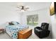 Bright bedroom features a starfish themed bedspread, mounted TV and comfortable leather chair for relaxing at 8804 Poe Dr, Hudson, FL 34667