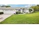 Beautiful single-story home featuring a lush green lawn and a charming front entrance with manicured landscaping at 8804 Poe Dr, Hudson, FL 34667
