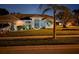 Charming single-story home with well-manicured landscaping and inviting front entrance at night at 8804 Poe Dr, Hudson, FL 34667