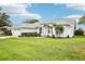 Beautiful single-story home featuring a lush green lawn and a charming front entrance with manicured landscaping at 8804 Poe Dr, Hudson, FL 34667