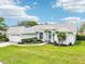 Beautiful single-story home featuring manicured landscaping, light exterior, and a well-maintained lawn at 8804 Poe Dr, Hudson, FL 34667