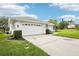 Spacious three car garage with an extended driveway and manicured shrubbery at 8804 Poe Dr, Hudson, FL 34667