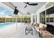 Relaxing screened patio features comfortable seating, ceiling fans, and a view of the pool at 8804 Poe Dr, Hudson, FL 34667