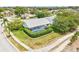 Overhead view of in-ground pool with screen, surrounded by manicured yard, landscaping and tall trees at 8804 Poe Dr, Hudson, FL 34667