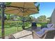 Backyard patio with comfortable seating and outdoor umbrella overlooking a serene water view at 9072 Baywood Park Dr, Seminole, FL 33777