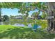 Picturesque backyard with lake view featuring mature trees and an Adirondack chair to sit and enjoy the view at 9072 Baywood Park Dr, Seminole, FL 33777