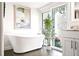 Bathroom showcasing a soaking tub, tile flooring, walk out access to outdoor patio, and a lush plant at 9072 Baywood Park Dr, Seminole, FL 33777