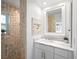 Modern bathroom featuring tiled shower, vanity with marble countertop, sink, and decorative mirror at 9072 Baywood Park Dr, Seminole, FL 33777