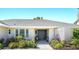 Close up of the home's entrance with double doors, a concrete path, and tasteful landscaping at 9072 Baywood Park Dr, Seminole, FL 33777