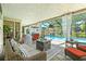 Outdoor living area with a covered lanai, comfortable seating, fireplace, and a sparkling pool at 9072 Baywood Park Dr, Seminole, FL 33777