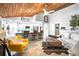 Open concept living room showcasing wood ceiling, kitchen bar, and modern decor at 9072 Baywood Park Dr, Seminole, FL 33777