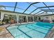 Sparkling pool with a screened-in enclosure, covered lanai, outdoor seating and manicured landscaping at 9072 Baywood Park Dr, Seminole, FL 33777