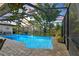 Beautiful pool area featuring a screen enclosure, view of the expansive backyard and surrounding greenery at 9072 Baywood Park Dr, Seminole, FL 33777