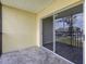 A covered balcony with tile flooring and a sliding glass door provides a serene outdoor retreat at 942 Capri Isles Blvd # 207, Venice, FL 34292