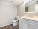 Bright bathroom featuring a marble-look vanity, wood-look flooring and a white framed mirror at 942 Capri Isles Blvd # 207, Venice, FL 34292