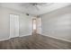 Neutral bedroom with wood-look floors, ceiling fan, and a closet behind white bi-fold doors at 942 Capri Isles Blvd # 207, Venice, FL 34292