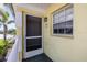 Close up of a condo front door with unit number, window, and exterior light fixture at 942 Capri Isles Blvd # 207, Venice, FL 34292