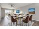 Staged living and dining area features hardwood floors and slider to outside at 942 Capri Isles Blvd # 207, Venice, FL 34292