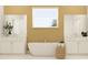 Luxurious bathroom featuring a soaking tub, dual vanities, modern fixtures, and neutral color scheme at 9645 Runaway Breeze Dr, Land O Lakes, FL 34637