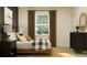 Well-decorated bedroom with a view, wooden bed frame, and neutral decor at 9645 Runaway Breeze Dr, Land O Lakes, FL 34637