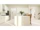 Bright kitchen with white island and seating, white cabinets, stainless steel appliances, and natural light from large windows at 9645 Runaway Breeze Dr, Land O Lakes, FL 34637