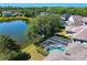 Scenic aerial view of a home with a screened-in pool and a tranquil lake at 10141 Deercliff Dr, Tampa, FL 33647