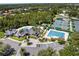 Aerial view showcases a community clubhouse, pool, tennis courts, parking and landscaping on a sunny day at 10141 Deercliff Dr, Tampa, FL 33647