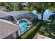 Aerial view of screened pool, spa, brick patio, and lush landscaping on waterfront property at 10141 Deercliff Dr, Tampa, FL 33647