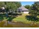 Lovely backyard featuring a screened-in pool, lush greenery, and a serene pond view at 10141 Deercliff Dr, Tampa, FL 33647