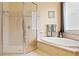 Corner tub and glass shower with beige tile in this bathroom, next to a window and neutral walls at 10141 Deercliff Dr, Tampa, FL 33647