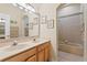 Bathroom with double vanity, mirror, lighting, framed art and an arched doorway to the bath/shower at 10141 Deercliff Dr, Tampa, FL 33647