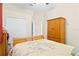 Bedroom with floral print bedding, an armoire, a double door closet and neutral colored walls at 10141 Deercliff Dr, Tampa, FL 33647
