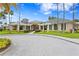 Beautiful clubhouse exterior with lush landscaping, tropical palm trees, and paver driveway at 10141 Deercliff Dr, Tampa, FL 33647