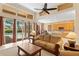 Comfortable living room with ceiling fan, high ceilings, and large windows with a view of the backyard pool at 10141 Deercliff Dr, Tampa, FL 33647