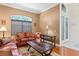 Cozy living room with hardwood floors, a leather sofa, and a large window for natural light at 10141 Deercliff Dr, Tampa, FL 33647