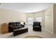 Comfortable living room with leather sofas and chairs and two arched windows letting in ample light at 10141 Deercliff Dr, Tampa, FL 33647