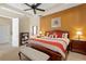 Spacious main bedroom with a tray ceiling, ceiling fan, wood furniture and a red, tan and white bedspread at 10141 Deercliff Dr, Tampa, FL 33647