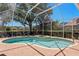 Lovely screened-in pool and spa with brick patio and view of the lush backyard at 10141 Deercliff Dr, Tampa, FL 33647