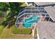 Aerial view of a sparkling screened-in pool and spa surrounded by a well-maintained backyard at 10141 Deercliff Dr, Tampa, FL 33647