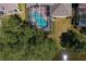 Aerial view of a screened-in pool and spa in a backyard near mature landscaping and a pond at 10141 Deercliff Dr, Tampa, FL 33647