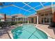 Inviting screened-in pool with a spa, brick patio, and view of the surrounding neighborhood at 10141 Deercliff Dr, Tampa, FL 33647