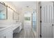 Bright bathroom leading to bedroom featuring dual sinks, marble counters, and glass shower at 10503 Dotham Ct, Tampa, FL 33626