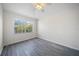 Well-lit bedroom with large window and ceiling fan, complete with gray wood-look flooring at 10503 Dotham Ct, Tampa, FL 33626