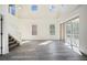 Large living room featuring tall ceilings, hardwood floors, staircase, and sliding door access to the backyard at 10503 Dotham Ct, Tampa, FL 33626