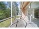 View of screened patio with large sliding doors to yard with mature trees at 10503 Dotham Ct, Tampa, FL 33626
