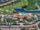 Community clubhouse aerial view featuring a pool, golf course, and well-maintained parking and landscaping at 1112 Jasmine Creek Ct, Sun City Center, FL 33573