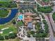 Overhead shot of community clubhouse with a pool, golf amenities, parking, and beautiful natural surroundings at 1112 Jasmine Creek Ct, Sun City Center, FL 33573